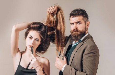 Friseurkonzept. Mode-Friseur macht modische Frisur, moderner Haarschnitt. Frau mit langen Haaren im Schönheitsstudio. Friseur schneidet Haare mit der Schere