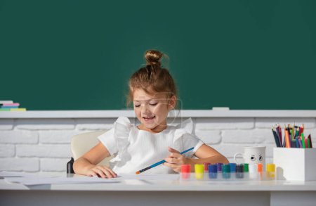 Foto de Niñas haciendo dibujos coloridos con lápices de colores en el aula de la escuela. Pintando niños. Linda chica de la escuela dibujo en clase en la escuela - Imagen libre de derechos