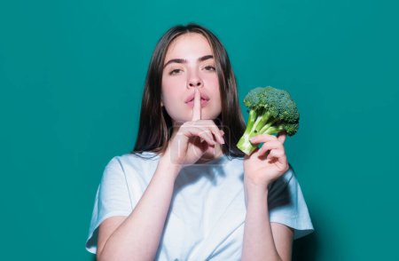 Photo for Secret woman diet. Healthy food, health life. Portrait of young beautiful woman eating broccoli, over blue background - Royalty Free Image