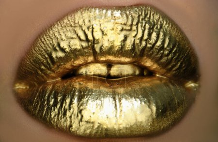 Téléchargez les photos : Lèvres dorées, rouge à lèvres doré sur les lèvres sexy, bouche métallique. Beauté maquillage femme de près. Effet doré sur les lèvres - en image libre de droit