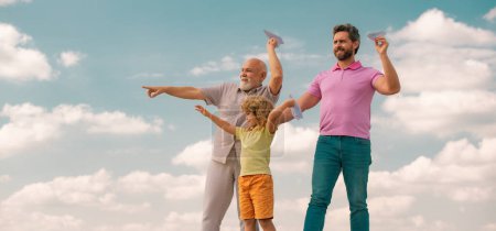 Foto de Tres generaciones diferentes edades abuelo padre e hijo hijo jugando con avión de juguete al aire libre - Imagen libre de derechos