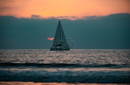 Foto de Navegando al amanecer con velero. Salida del sol sobre el mar y hermoso paisaje nublado. Colorido océano playa puesta de sol - Imagen libre de derechos