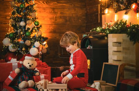 Photo for Lovely baby enjoy christmas. Family holiday. Childhood memories. Santa boy celebrate christmas at home. Boy child play near christmas tree. Merry and bright christmas. Childhood activity and game. - Royalty Free Image