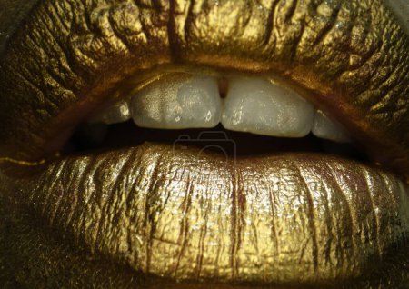 Foto de Labios dorados macro de cerca. Cosméticos y maquillaje. Lápiz labial y brillo de labios dorados. Labios sexys y sensuales. Primeros labios dorados - Imagen libre de derechos