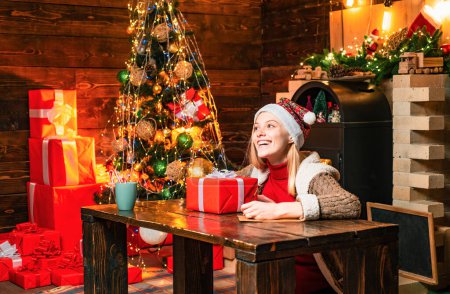 Photo for Filled with happiness cheer and love. Girl enjoy cozy warm atmosphere christmas eve. Christmas joy. Woman wooden interior christmas decorations garland lights. Christmas tree. Pleasant moments. - Royalty Free Image
