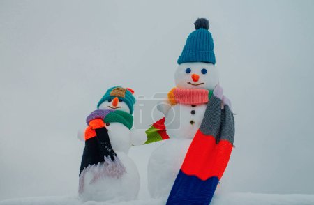 Téléchargez les photos : Bonhomme de neige. Bonhomme de neige isolé sur fond de neige. Deux bonhomme de neige sur fond de neige - en image libre de droit