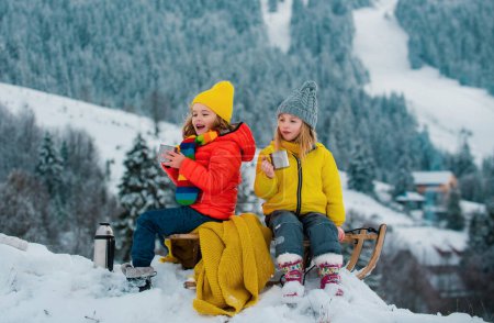 Photo for Happy little boy and girl sledding in winter. Kids sibling riding on snow slides in winter. Son and daughter enjoy a sleigh ride - Royalty Free Image