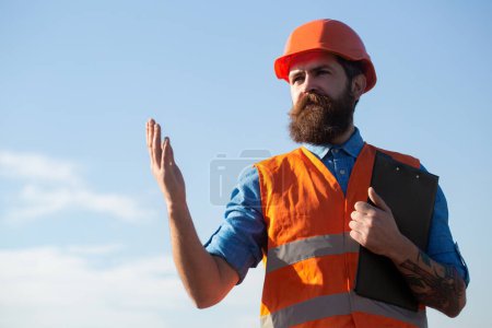 Photo for Male construction worker in work clothes and a construction helmet. Portrait of construction worker outdoor - Royalty Free Image