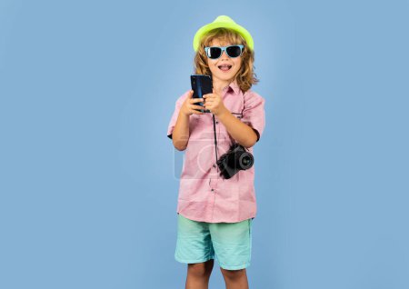 Téléchargez les photos : Touriste enfant. Enfant vlogger passer un appel vidéo, bavarder. Enfant blogueur touristique faisant photo pour les réseaux sociaux sur le téléphone. Voyages avec enfants, tourisme - en image libre de droit