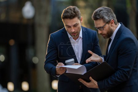 Photo for Business discussion. Businessman sharing his experience. Business partners meeting outdoor. Two confident business people in formalwear discussing something while sitting at the street - Royalty Free Image