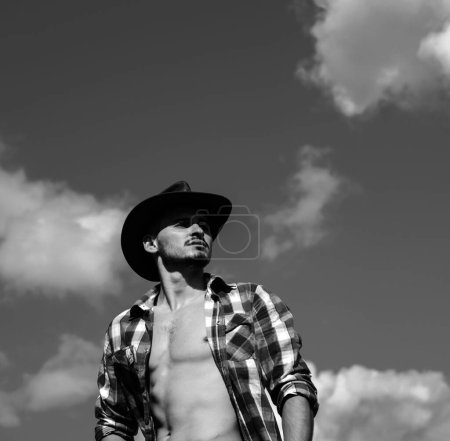 Foto de Chico guapo de moda en sombrero de vaquero en mira a la cámara, Hombre de moda - Imagen libre de derechos