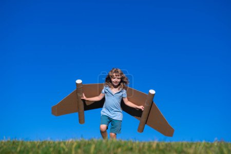Photo for Little child plays astronaut or pilot. Child on the background of blue sky. Kids with paper wings jetpack dreams. Children imagines dreams of flying. Funny kid with toy jet pack. Success, imagination - Royalty Free Image