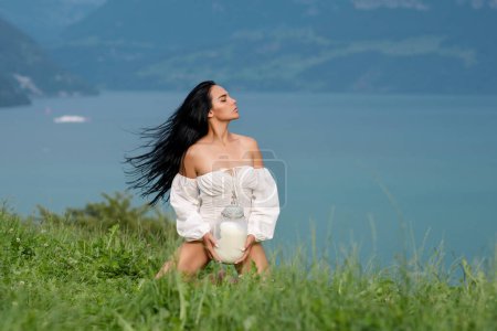Photo for Sexy Milk. Young woman in lingerie drinking milk outside. Model drink Milk near green grass an Alpine lake. Young woman drinking milk from bottle on alpine mountain. Farm on Switzerland - Royalty Free Image