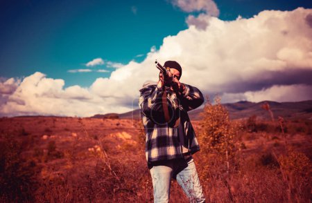 Téléchargez les photos : Chasseur avec fusil de chasse en chasse. Saison de chasse d'automne. Chasseur pendant la saison de chasse d'automne - en image libre de droit