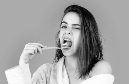 Foto de Retrato divertido de una hermosa mujer feliz cepillándose los dientes con un cepillo de dientes fondo aislado - Imagen libre de derechos