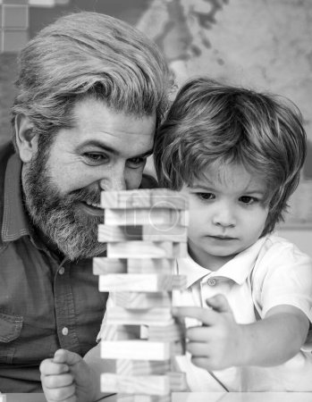 Photo for Father and son playing stacking wood blocks Jenga games for meditation practice. Children building wood blocks at home. - Royalty Free Image