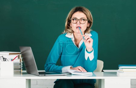 Foto de Moderno profesor atractivo. Retrato de una joven inteligente en gafas con libro en la pizarra en clase en la escuela secundaria o collage. Estudiante femenina en la universidad. Educación, escuela y personas - Imagen libre de derechos