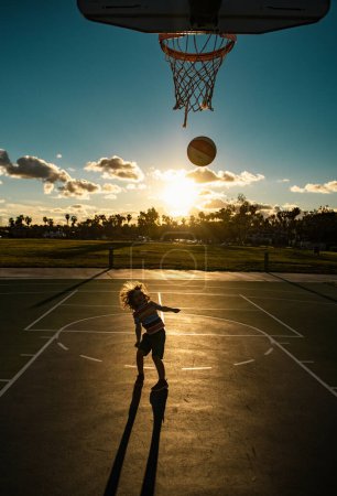 Foto de Jugador de Basket ball kids. Deporte para niños silueta al atardecer - Imagen libre de derechos