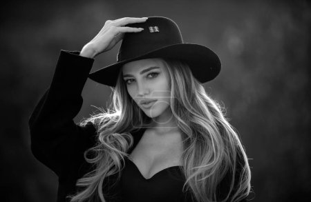 Foto de Sensual retrato de mujer joven y elegante en amplio sombrero de ala ancha al aire libre. Hermosa chica de moda - Imagen libre de derechos