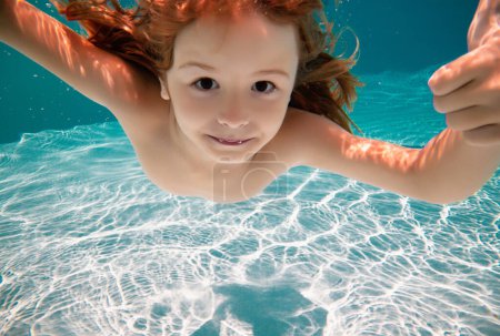 Foto de Niño nadando bajo el agua. Niño nadar bajo el agua en la piscina - Imagen libre de derechos
