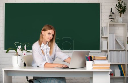 Photo for Focused student, young woman online watching webinar on laptop, listening learning education course, sit at work desk in classroom, elearning concept. Education in high school, university - Royalty Free Image