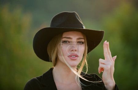 Photo for Beautiful woman in fashion hat. Cowgirl in cowboy hat with finger gun. Spring romantic casual woman portrait. Beautiful girl outdoor, close up beauty young female face. Trendy summer hat - Royalty Free Image