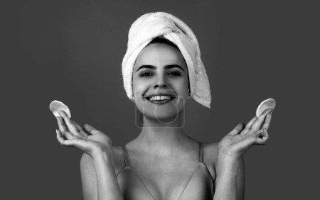 Foto de Mujer sonriente con la cara tranquila, disfruta de los procedimientos de baño, toalla envuelta en la cabeza, aislado en el fondo del estudio. Mañana, higiene. Después de Spa. Mujer hermosa con la piel perfecta después del tratamiento de belleza - Imagen libre de derechos
