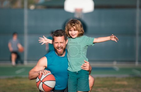 Téléchargez les photos : Père et fils jouent au basket. Concept de vacances saines et d'activité familiale - en image libre de droit