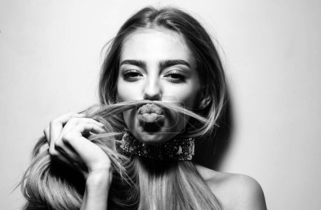 Photo for Young woman making mock moustache with her hair. Gorgeous seductive model girl with long hair. Beauty girl, beautiful blonde women hair - Royalty Free Image