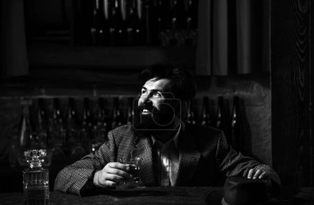 Photo for Handsome bearded man enjoying whiskey in bar. Hipster drinking a brandy in bar - Royalty Free Image