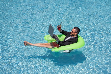 Photo for Summer vacations and freedom travel concept. Portrait of hispanic business man on the beach. Businessman in suit floating with laptop and cocktail in pool. Crazy business man dreams summer vacation - Royalty Free Image