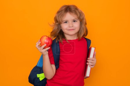 Photo for Back to school. School boy with book and apple. School child student learning. Elementary school child. Portrait of funny pupil learning on yellow isolated background - Royalty Free Image