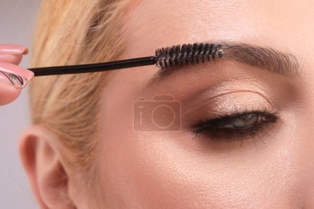 Photo for Beautiful woman with perfect shape eyebrows. Womans brows close up. Beautiful girl with eyebrow brush. Eyebrow correction. Long eyelashes and thick eyebrows - Royalty Free Image