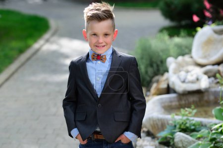 Photo for Fashion kid boy in suit and bow tie. Portrait of kid outdoors. Close-up face child playing outdoors in summer park - Royalty Free Image