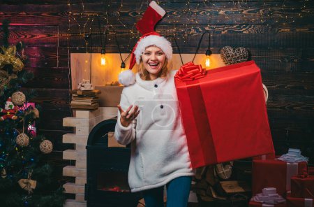 Foto de Preparación navideña. Chica sonriente disfrazada de Santa Claus. Mujer con cajas de regalo de Navidad rojas. Mujer de Navidad. Mujer sonrisa Navidad - Imagen libre de derechos