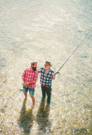 Téléchargez les photos : Week-ends de pêche. Un passe-temps masculin. Équipements de pêche des pêcheurs. Unis à la nature. Un pêcheur attrape un poisson. Hobby de l'homme d'affaires. Pêcheur avec canne à pêche - en image libre de droit
