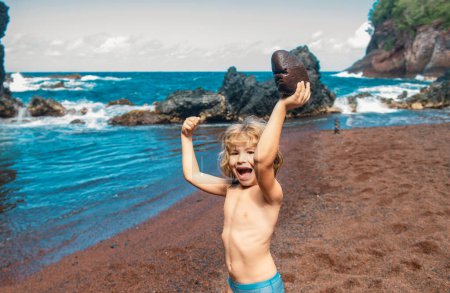 Téléchargez les photos : Enfant jouant dans la plage de sable de la mer. Enfants vacances d'été et concept de voyage - en image libre de droit