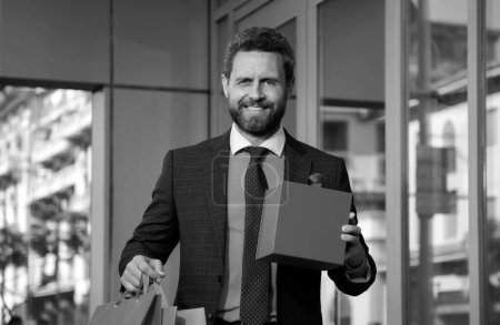 Photo for Great present. Man with gift box and smiling while standing against city - Royalty Free Image