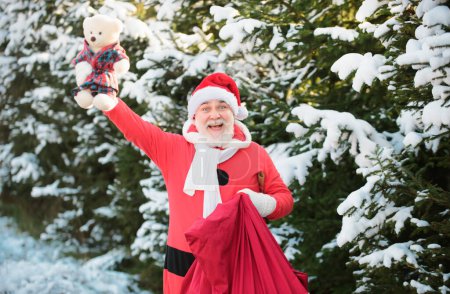 Foto de Santa Claus con una bolsa de regalos de Navidad viene en el bosque de nieve - Imagen libre de derechos