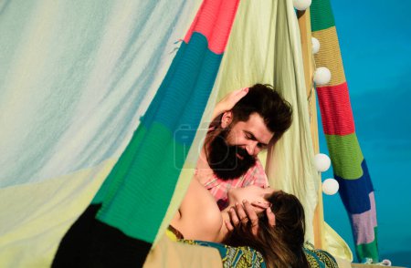 Téléchargez les photos : Couple dans une tente. Jeune couple amoureux passe du temps ensemble et camper. Homme embrassant et allant embrasser femme sensuelle - en image libre de droit