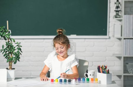 Téléchargez les photos : Child girl at school draws with paints. Kids artist creativity. Kids creative growth - en image libre de droit