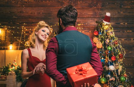 Foto de Sorprendida pareja de Navidad. Pareja familiar que celebra el año nuevo o un evento. Una pareja muy hermosa sobre el árbol de Navidad. Emociones emocionadas y felices - Imagen libre de derechos