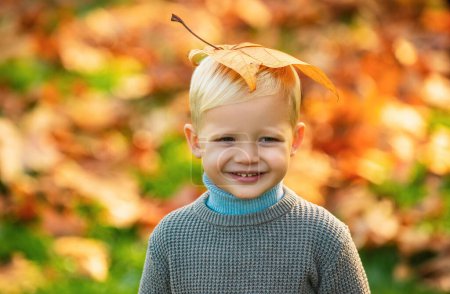 Téléchargez les photos : Enfant avec feuille jaune dans le parc d'automne. Petit garçon mignon profiter de la nature d'automne a visage heureux. Portrait d'enfant. sourire les enfants visage - en image libre de droit