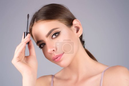 Foto de Female model shaping brown eyebrows. Woman eye with beautiful eyebrows. Perfect shaped brow, eyelashes with brow gel brush. Paint eyebrows - Imagen libre de derechos