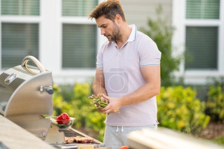 Photo for Men cooking on barbecue grill in yard - Royalty Free Image