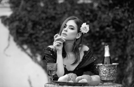 Foto de Mujer sexy joven relajarse y comer fruta al aire libre. Dieta exótica de verano, frutas tropicales - Imagen libre de derechos
