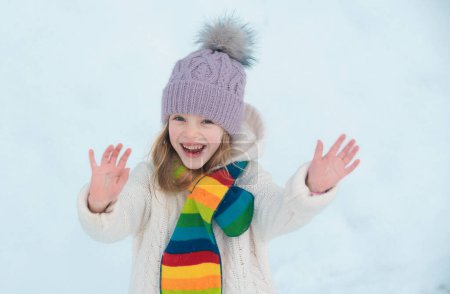 Photo for Funny excited child girl face in snow on winter outdoor. Children in winter outdoor in frost snowy day. Amazed kid resting together in park with winter background. Happy childhood - Royalty Free Image
