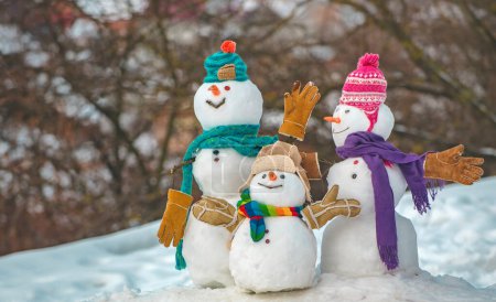 Foto de Feliz pareja de muñecos de nieve y niño muñeco de nieve con regalo de Navidad de pie en invierno paisaje de Navidad. Tarjeta de felicitación de Año Nuevo. Feliz Navidad y feliz año nuevo tarjeta de felicitación. Banner de venta de invierno - Imagen libre de derechos