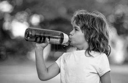 Téléchargez les photos : Enfant sportif boire de l'eau de bouteille de sport. Sport et fitness pour enfants, santé et énergie. Mode de vie sain des enfants. Activités pour enfants en plein air - en image libre de droit