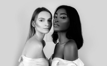Téléchargez les photos : Portrait de femmes de races mixtes peau féminine noire et blanche. Mixte races beauté caucasienne et afro afro filles américaines. Beauté multi-ethnique. Deux filles d'ethnie différente en gros plan. Soins de la peau et maquillage - en image libre de droit